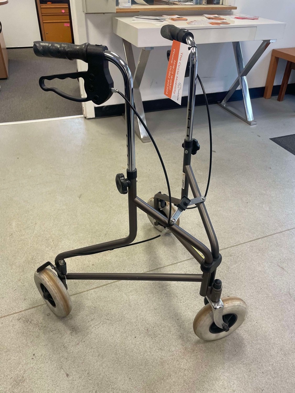 A grey Coopers three-wheeled walker