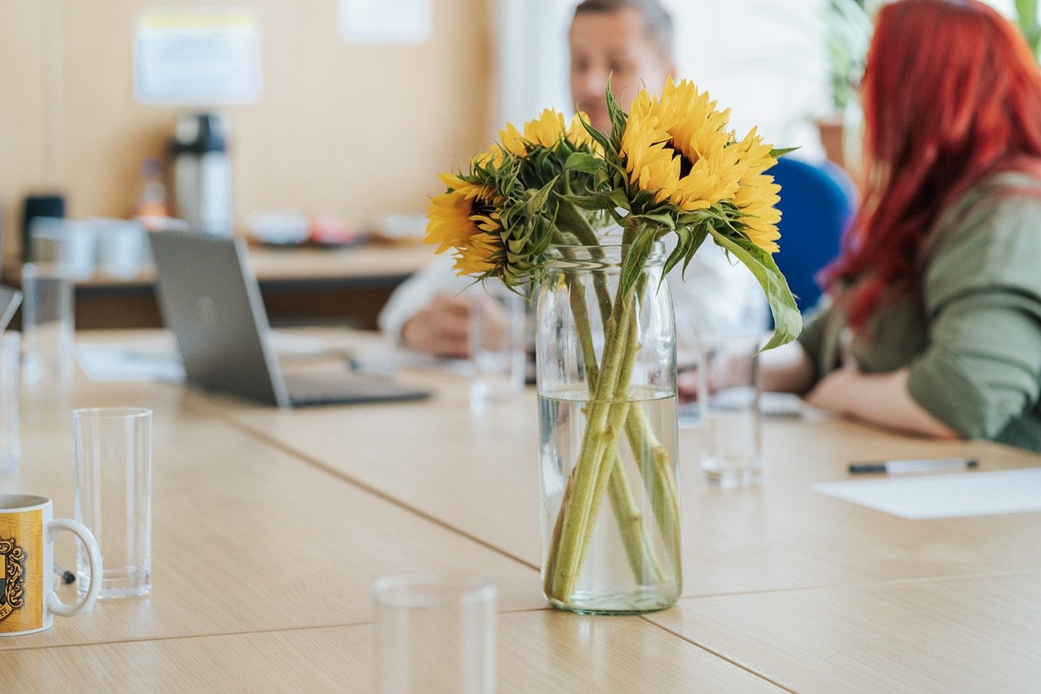 The Circle Dundee training room, with sunflowers on the table and two tenants meeting